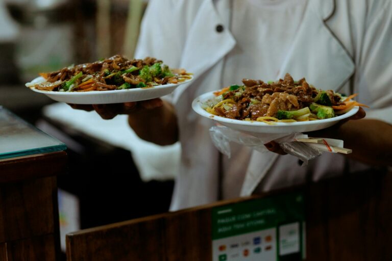 Beef and broccoli stir-fry in a wok with glossy brown sauce and sesame seeds
