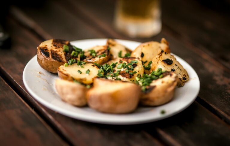 Crispy smashed potatoes with herbs and flaky salt on a baking tray