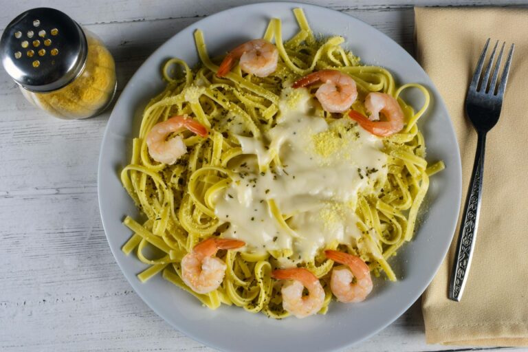 A bowl of linguine pasta tossed with garlic butter shrimp, lemon, and fresh parsley